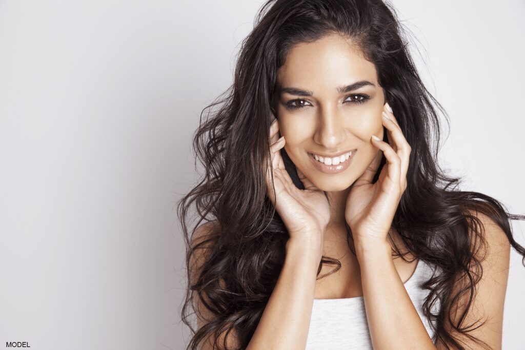 Smiling woman with long, wavy hair.